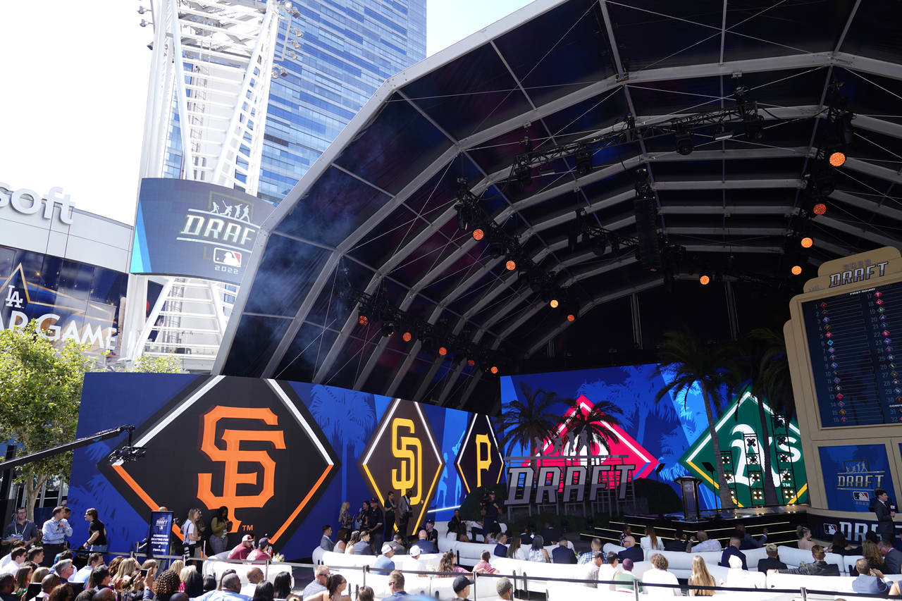 Logos from various teams are displayed during the 2022 MLB baseball draft, Sunday, July 17, 2022, i...