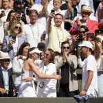 
              Kazakhstan's Elena Rybakina is embraced by family, friends and coaches in the players box as she celebrates after beating Tunisia's Ons Jabeur to win the final of the women's singles on day thirteen of the Wimbledon tennis championships in London, Saturday, July 9, 2022. (AP Photo/Gerald Herbert)
            