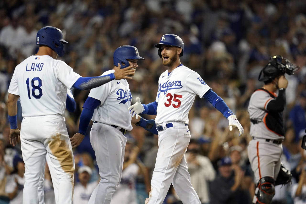 Los Angeles Dodgers' Cody Bellinger (35) celebrates his grand slam at home plate with Max Muncy and...