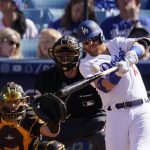 
              Los Angeles Dodgers' Justin Turner, right, hits a solo home run as San Diego Padres catcher Austin Nola, left, and home plate umpire Ben May watch during the first inning of a baseball game Saturday, July 2, 2022, in Los Angeles. (AP Photo/Mark J. Terrill)
            