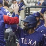 
              Texas Rangers' Marcus Semien high-fives teammates in the dugout after his third-inning home run against the New York Mets in a baseball game Friday, July 1, 2022, in New York. (AP Photo/Bebeto Matthews)
            