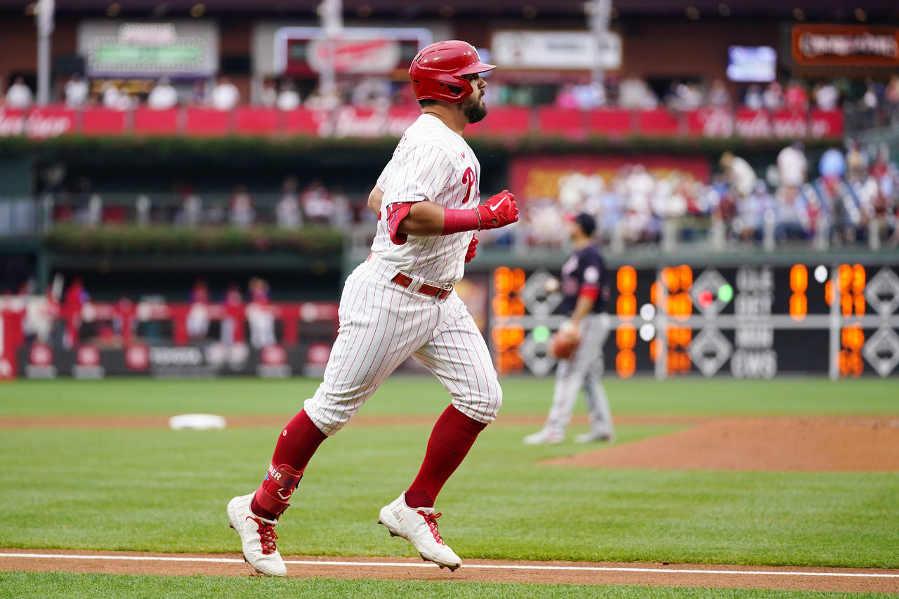 Philadelphia Phillies' Kyle Schwarber, left, rounds the bases after hitting a home run against Wash...