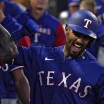 
              Texas Rangers' Marcus Semien, right, is congratulated by teammates in the dugout after hitting a double and then advancing to home on a fielding error by Los Angeles Angels left fielder Jo Adell during the sixth inning of a baseball game Friday, July 29, 2022, in Anaheim, Calif. (AP Photo/Mark J. Terrill)
            