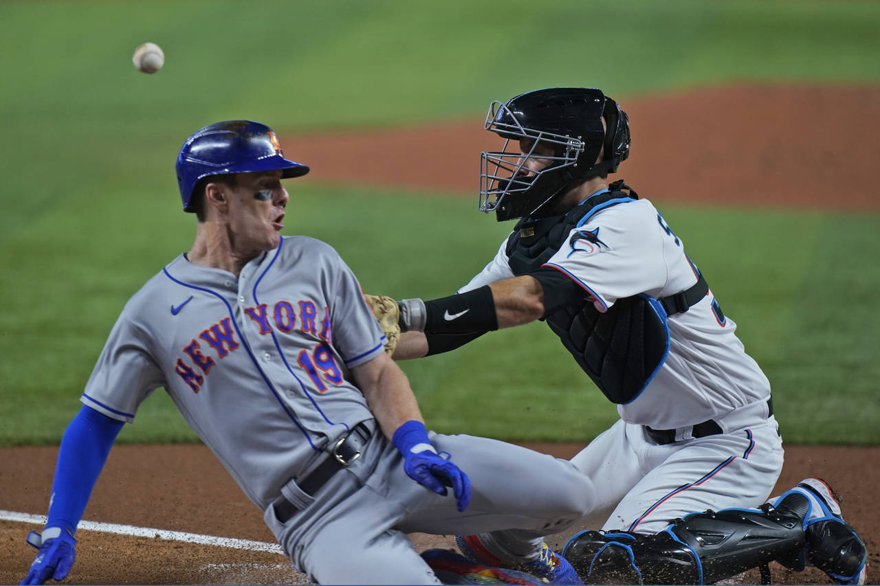 Miami Marlins catcher Jacob Stallings, right, is unable to hang on to the throw as New York Mets' M...