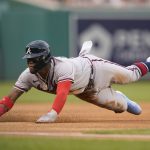 
              Atlanta Braves' Ronald Acuna Jr. dives safely into third base after a throwing error by Washington Nationals catcher Keibert Ruiz at second in the first inning of a baseball game, Thursday, July 14, 2022, in Washington. (AP Photo/Patrick Semansky)
            