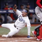 
              Tampa Bay Rays' Josh Lowe scores next to Boston Red Sox catcher Kevin Plawecki during the seventh inning of a baseball game Thursday, July 14, 2022, in St. Petersburg, Fla. (AP Photo/Scott Audette)
            