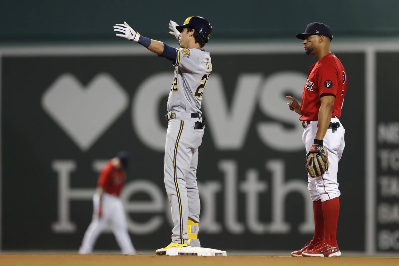 Milwaukee Brewers' Christian Yelich (22) gestures after his double, next to Boston Red Sox's Xander...