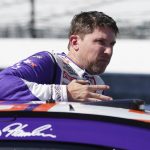 
              Denny Hamlin climbs out of his car during qualifications for the NASCAR Cup Series auto race at Indianapolis Motor Speedway, Saturday, July 30, 2022, in Indianapolis. (AP Photo/Darron Cummings)
            
