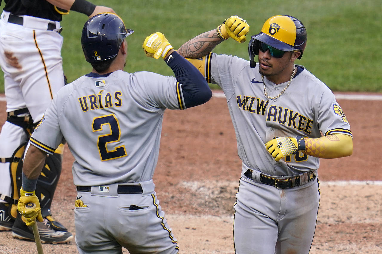 Milwaukee Brewers' Kolten Wong, right, celebrates with Luis Urias after hitting a solo home run off...