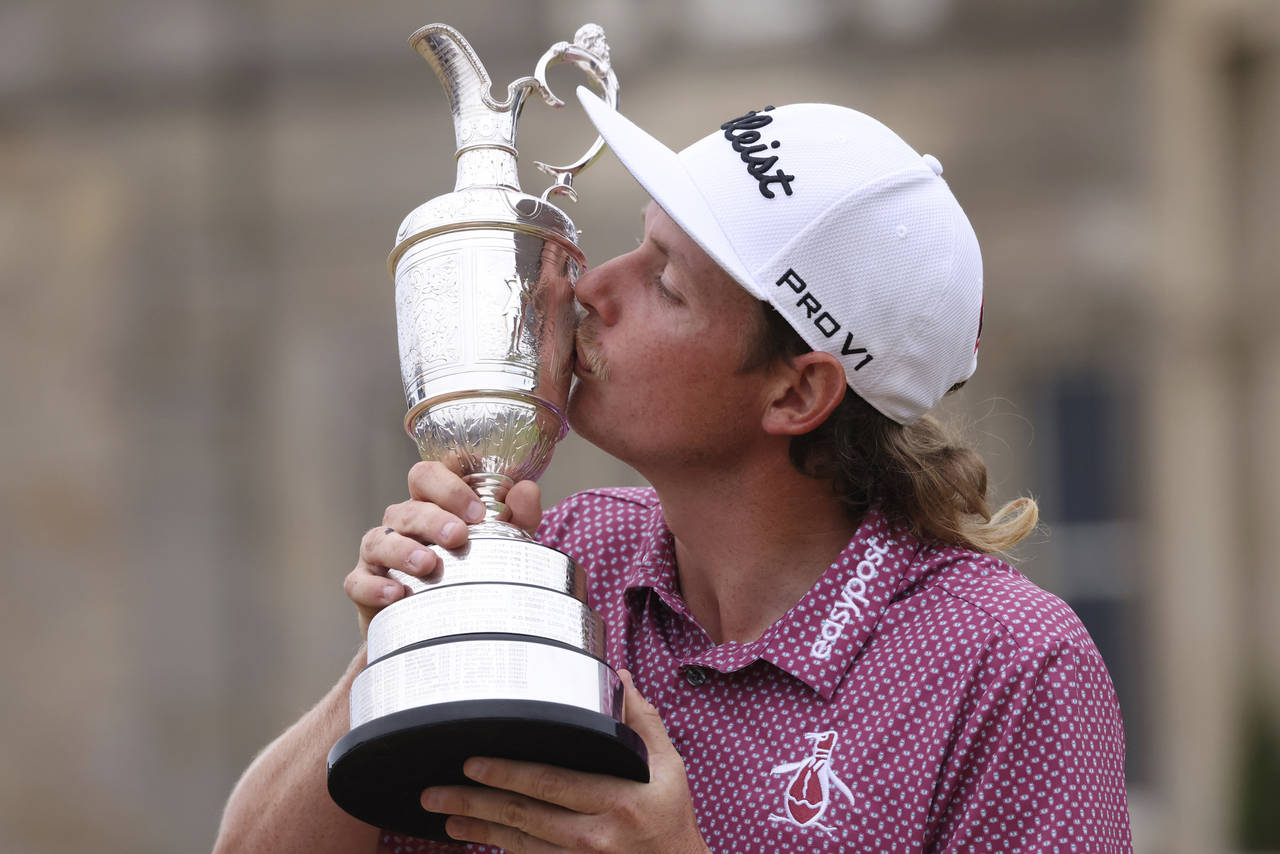 Cameron Smith, of Australia, kisses the claret jug trophy as he poses for photographers on the 18th...