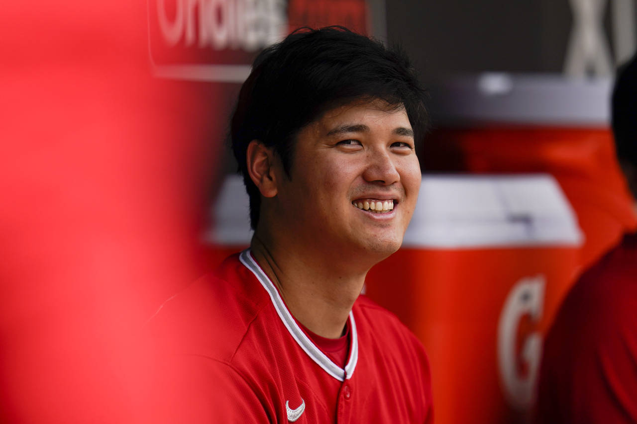 Los Angeles Angels designated hitter Shohei Ohtani sits in the dugout during the fourth inning of a...