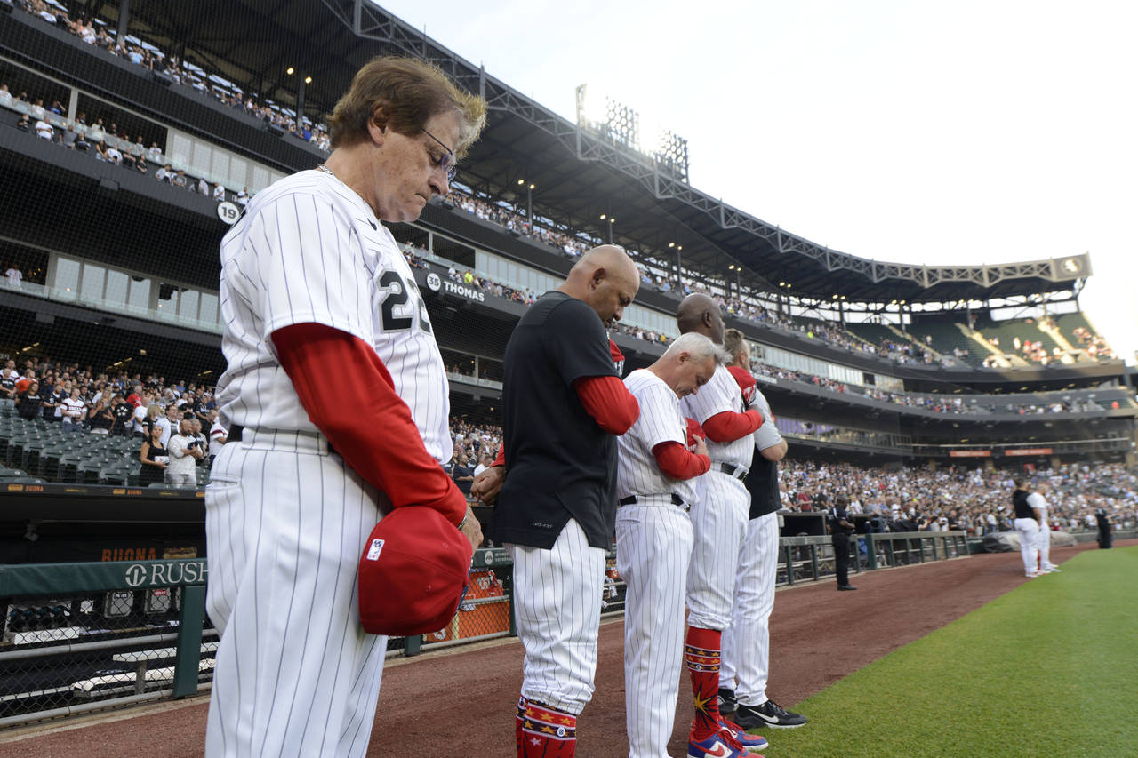 Chicago White Sox manager Tony La Russa left, and his coaches bow their heads during a moment of si...