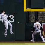 
              San Francisco Giants center fielder Austin Slater, left, is unable to make a play on a double hit by Arizona Diamondbacks' David Peralta as Giants right fielder Luis Gonzalez (51) looks on during the fourth inning of a baseball game Monday, July 25, 2022, in Phoenix. (AP Photo/Ross D. Franklin)
            