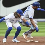 
              Toronto Blue Jays shortstop Bo Bichette, left, tags out Kansas City Royals' Edward Olivares on an attempted steal during the third inning of a baseball game Thursday, July 14, 2022, in Toronto. (Jon Blacker/The Canadian Press via AP)
            