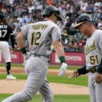 
              Oakland Athletics' Sean Murphy (12) celebrates his home run with third base coach Darren Bush off Chicago White Sox starting pitcher Johnny Cueto (47) during the first inning of a baseball game Saturday, July 30, 2022, in Chicago. (AP Photo/Charles Rex Arbogast)
            