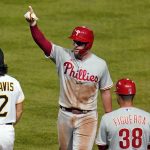 
              Philadelphia Phillies' Rhys Hoskins, center, celebrates at first base after driving in a run with a single off Pittsburgh Pirates relief pitcher Wil Crowe during the seventh inning of a baseball game in Pittsburgh, Friday, July 29, 2022. (AP Photo/Gene J. Puskar)
            