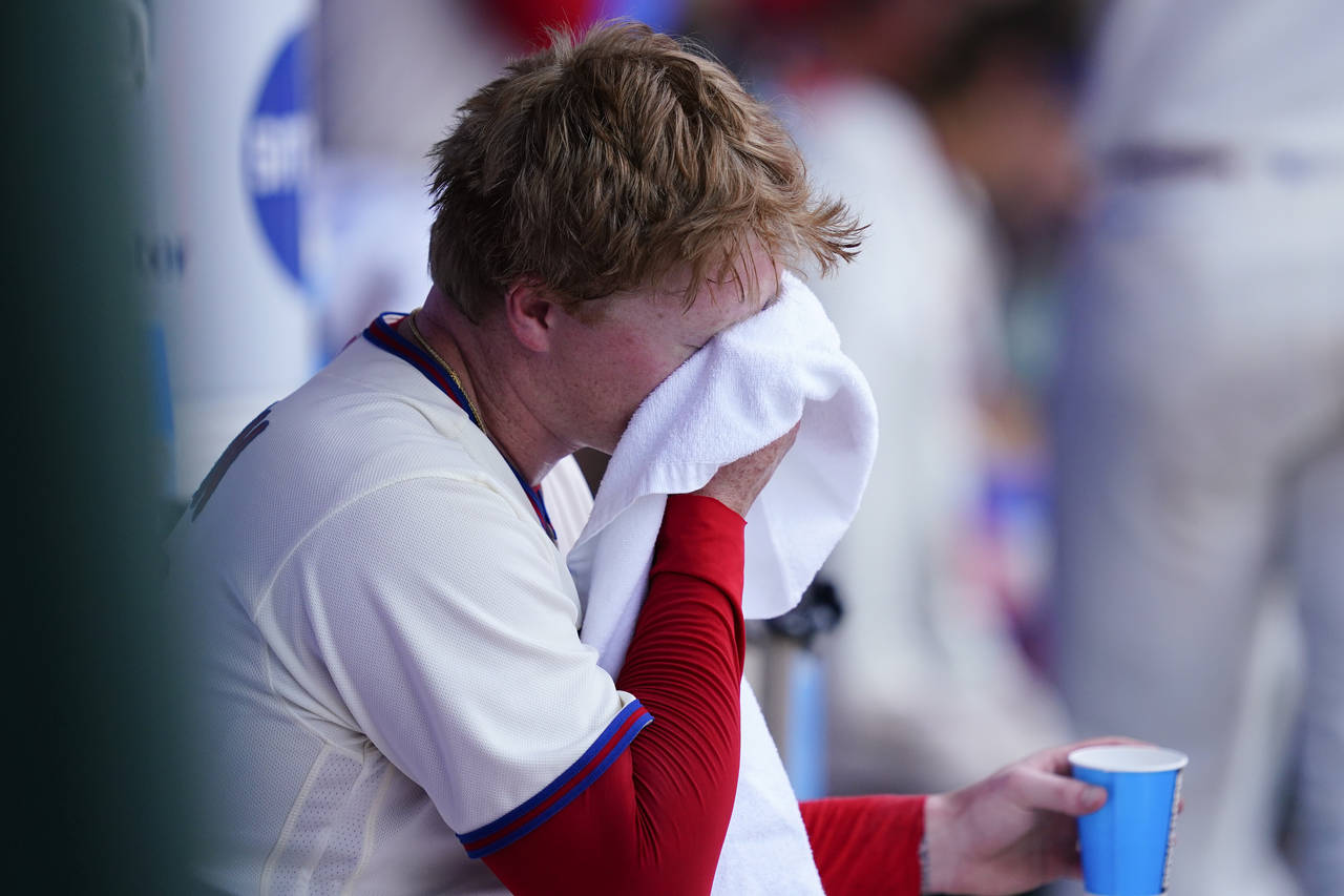 Philadelphia Phillies' Nick Nelson wipes his face in the dugout out during the sixth inning of a ba...