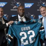 
              Mike Grier, middle, poses for photos as he is introduced as the new general manager of the San Jose Sharks between assistant general manager Joe Will, left, and president Jonathan Becher at a news conference in San Jose, Calif., Tuesday, July 5, 2022. (AP Photo/Jeff Chiu)
            