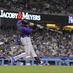 
              Colorado Rockies' Kris Bryant, right, hits a solo home run as Los Angeles Dodgers catcher Will Smith watches during the sixth inning of a baseball game Tuesday, July 5, 2022, in Los Angeles. (AP Photo/Mark J. Terrill)
            