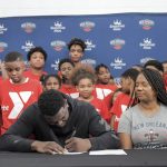 
              New Orleans Pelicans forward Zion Williamson, center, signs his contract extension surrounded by his family and children attending camp at the Dryades YMCA in New Orleans, Wednesday, July 6, 2022. (Max Becherer/The Times-Picayune/The New Orleans Advocate via AP)
            