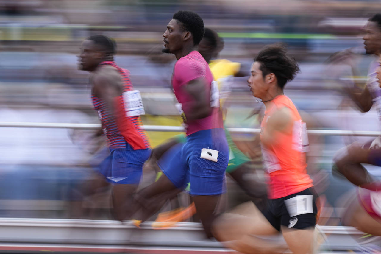 Fred Kerley, of the United States, (pink shirt) wins a semifinal in the men's 100-meter run at the ...