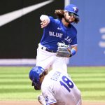 
              Toronto Blue Jays shortstop Bo Bichette, top, throws to first base to complete a double play on Kansas City Royals' Nick Pratto, and forcing out Royals' Nate Eaton, bottom, in the first inning of a baseball game in Toronto, Sunday, July 17, 2022. (Jon Blacker/The Canadian Press via AP)
            