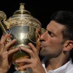 
              Serbia's Novak Djokovic kisses the trophy as he celebrates after beating Australia's Nick Kyrgios to win the final of the men's singles on day fourteen of the Wimbledon tennis championships in London, Sunday, July 10, 2022. (AP Photo/Kirsty Wigglesworth)
            