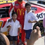 
              NASCAR driver Bubba Wallace poses with two youngsters at Navy Pier on Tuesday, July 19, 2022, Chicago during a promotional visit to announce a Cup Series street race to be held July 2, 2023, in the city. (AP Photo/Charles Rex Arbogast)
            