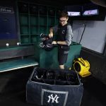 
              Clubhouse attendant Tyler Danburg packs the New York Yankees' helmets after the team's baseball game against the Cleveland Guardians was postponed Friday, July 1, 2022, in Cleveland. (AP Photo/Ron Schwane)
            