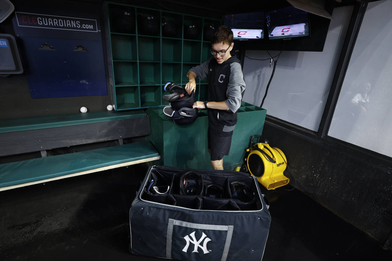 Clubhouse attendant Tyler Danburg packs the New York Yankees' helmets after the team's baseball gam...