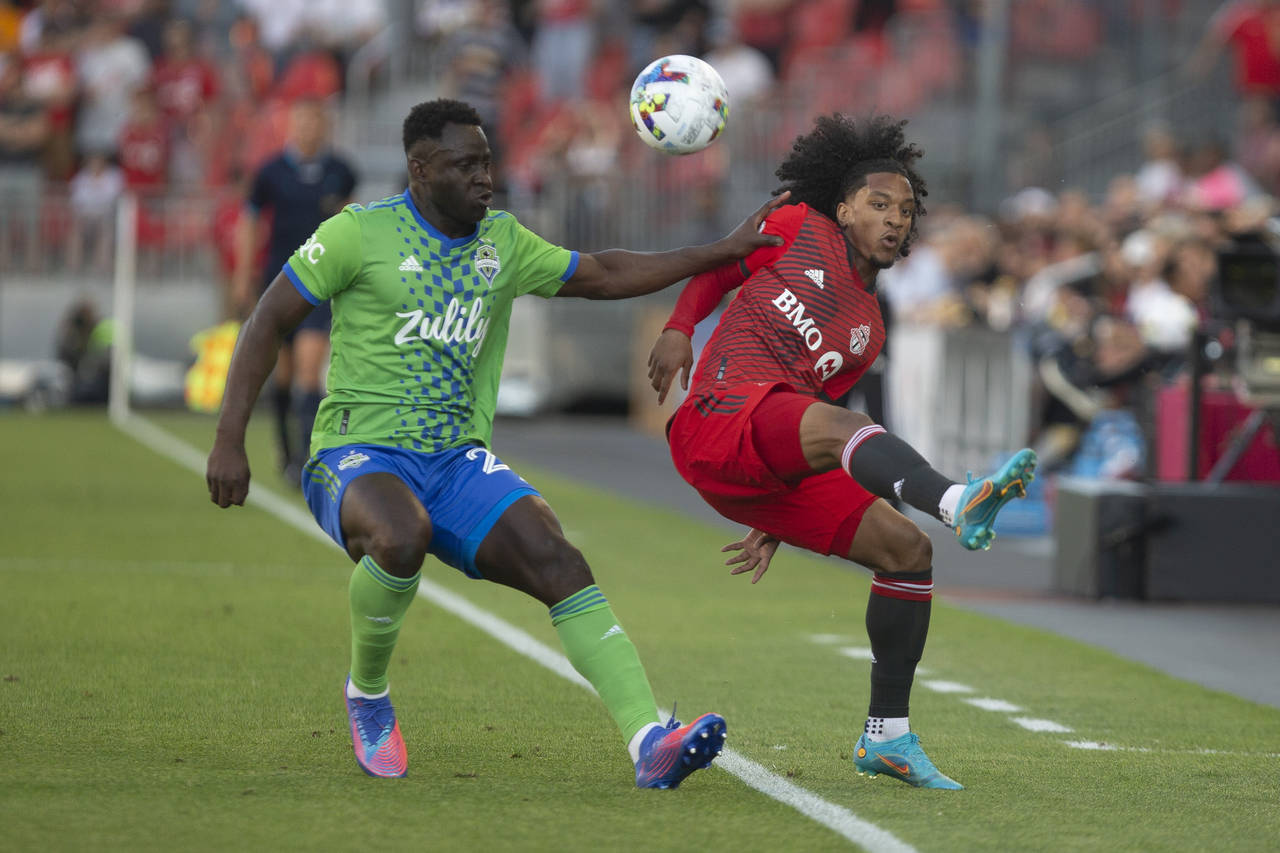 Toronto FC forward Jayden Nelson, right, flicks the ball over the head of Seattle Sounders defender...