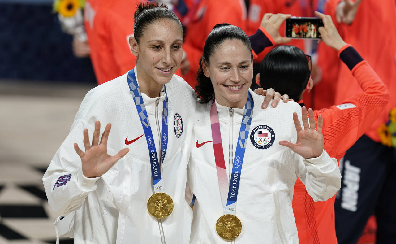 FILE - United States's Diana Taurasi, left, and Sue Bird pose with their gold medals during the med...