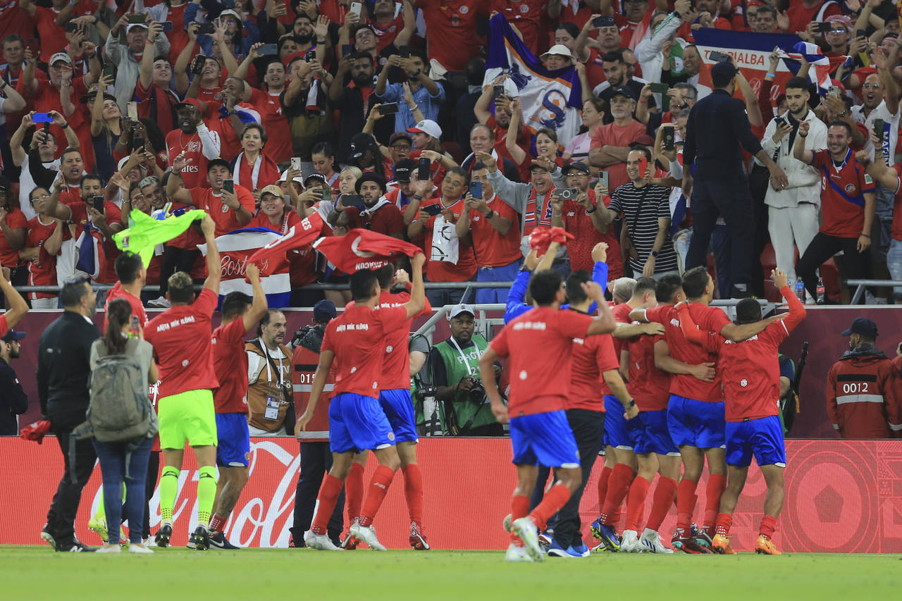 Costa Rica's players celebrate after the World Cup 2022 qualifying play-off soccer match between Ne...