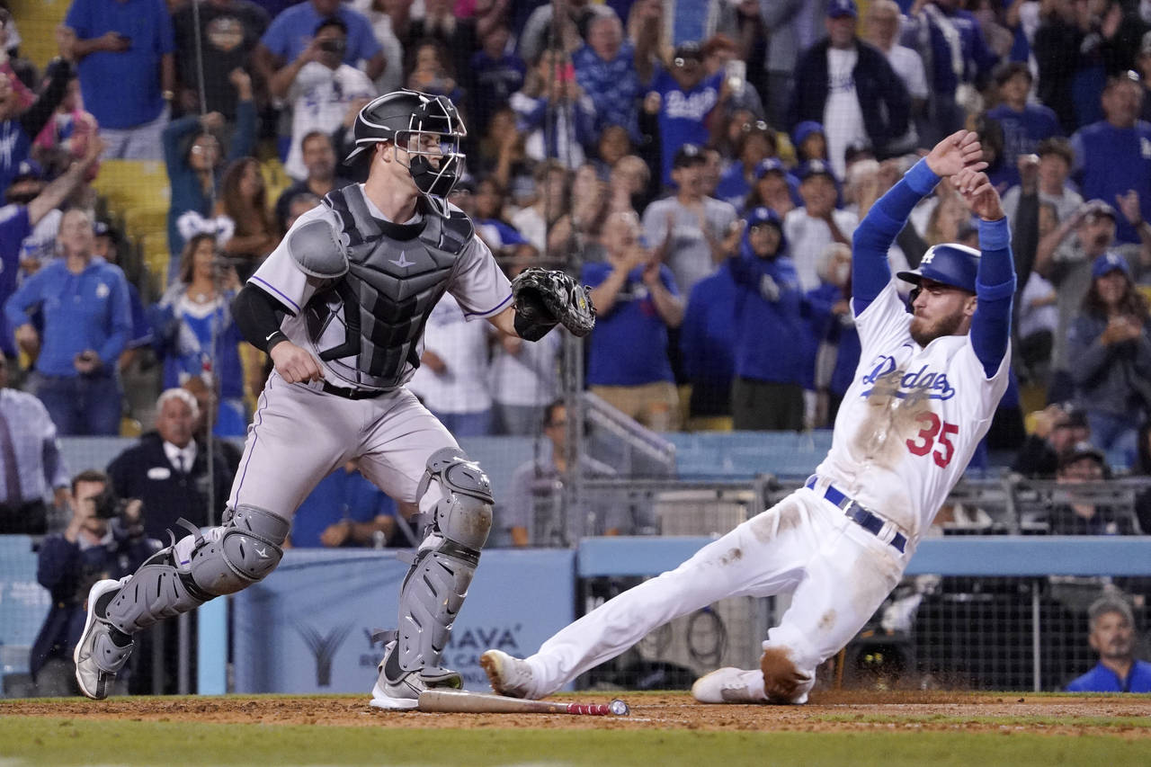 Los Angeles Dodgers' Cody Bellinger, right, scores the winning run on a single by Mookie Betts as C...