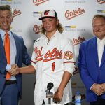 
              CORRECTS DATE -  Jackson Holliday, center, the first overall draft pick by the Baltimore Orioles in the 2022 draft, poses for photos with general manager Mike Elias, left, and agent Scot Boras during a news conference introducing him to the Baltimore media prior to a baseball game between the Baltimore Orioles and the Tampa Bay Rays, Wednesday, July 27, 2022, in Baltimore. (AP Photo/Julio Cortez)
            