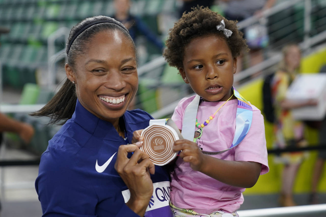 Allyson Felix, of the United States, gives her daughter Camryn her bronze medal after the 4x400-met...
