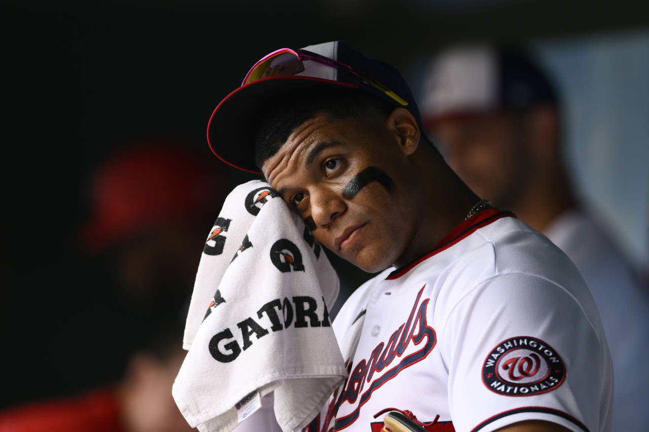 Washington Nationals' Juan Soto wipes his face in the dugout before a baseball game against the Atl...