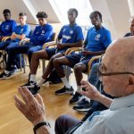
              CORRECTS SPELLING OF NAME TO SHAUL PAUL LADANY INSTEAD OF SHAUL PAUL LADY - Holocaust survivor Shaul Paul Ladany talks to youth players of FC Chelsea in Nuremberg, Germany, Friday, July 29, 2022. Some of Europe's best young soccer players from the under-17 teams of Chelsea, Bayern Munich, Bologna and other international clubs contest the Walther Bensemann Memorial Tournament in Nuremberg, where they also learn the dangers of intolerance by meeting Holocaust survivors, attending workshops and taking part in excursions. (AP Photo/Michael Probst)
            