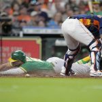 
              Oakland Athletics' Seth Brown, bottom left, slides safely past Houston Astros catcher Martin Maldonado to score on Stephen Vogt's sacrifice fly during the sixth inning of a baseball game, Sunday, July 17, 2022, in Houston. (AP Photo/Eric Christian Smith)
            