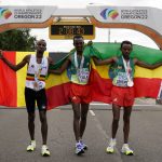 
              Gold medalist Tamirat Tola, of Ethiopia, center, stands with silver medalist Mosinet Geremew, of Ethiopia, right, and bronze medalist Bashir Abdi, of Belgium, after the men's marathon at the World Athletics Championships on Sunday, July 17, 2022, in Eugene, Ore. (AP Photo/Gregory Bull)
            