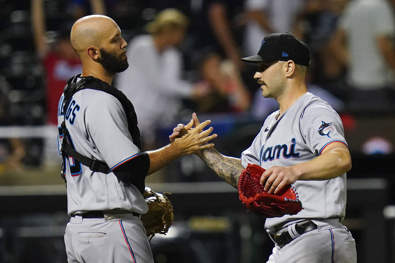Miami Marlins relief pitcher Tanner Scott, right, celebrates with catcher Jacob Stallings, left, af...