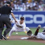 
              San Diego Padres second baseman Jake Cronenworth, center, attempts to catch the ball as San Francisco Giants' Thairo Estrada, right, safely steals the base in the eighth inning of a baseball game Saturday, July 9, 2022, in San Diego. (AP Photo/Derrick Tuskan)
            