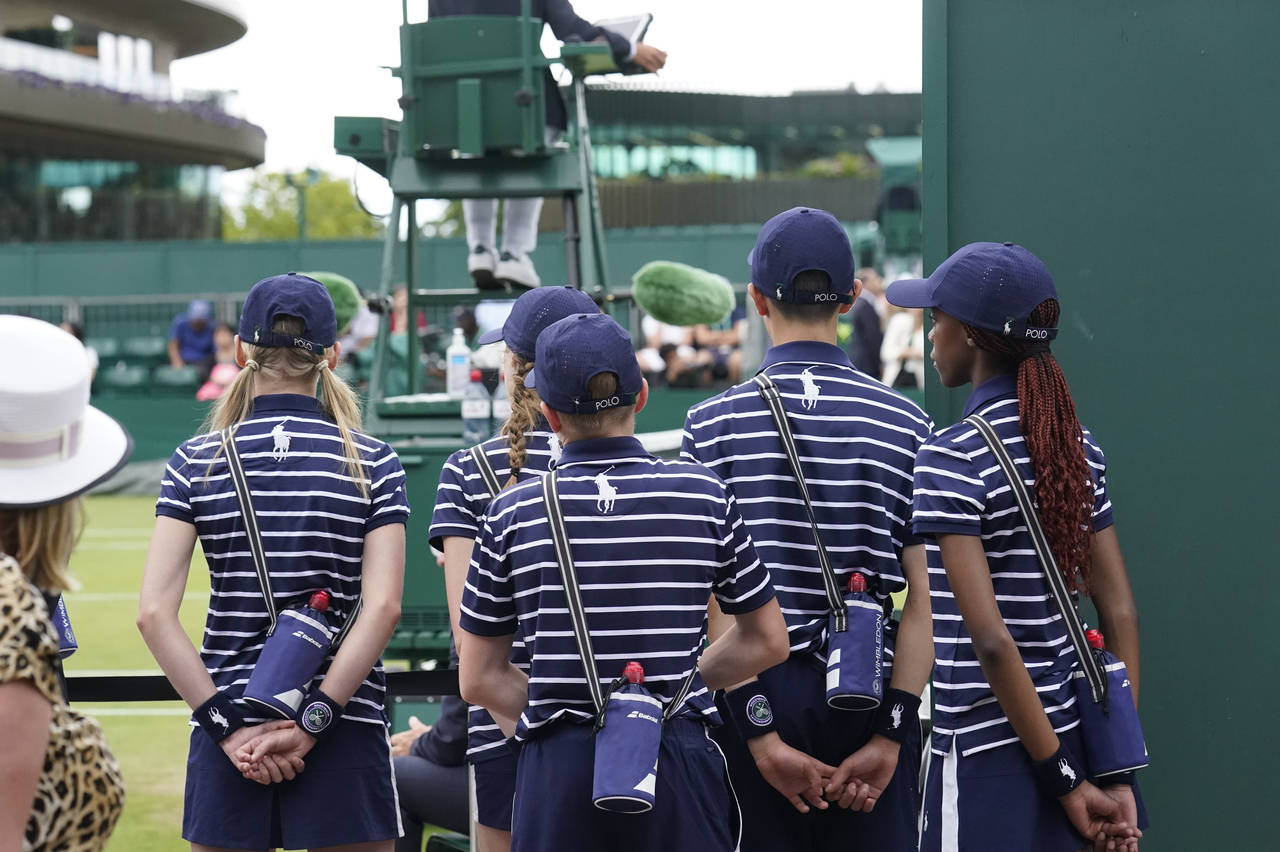 Ballboys and ballgirls wait to enter a court for a match on court 12 on day ten of the Wimbledon te...