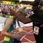 
              Wilbert Greaves gives gold medalist Eleanor Patterson, of Australia, her medal after the final of the men's discus throw at the World Athletics Championships on Tuesday, July 19, 2022, in Eugene, Ore. (AP Photo/Charlie Riedel)
            