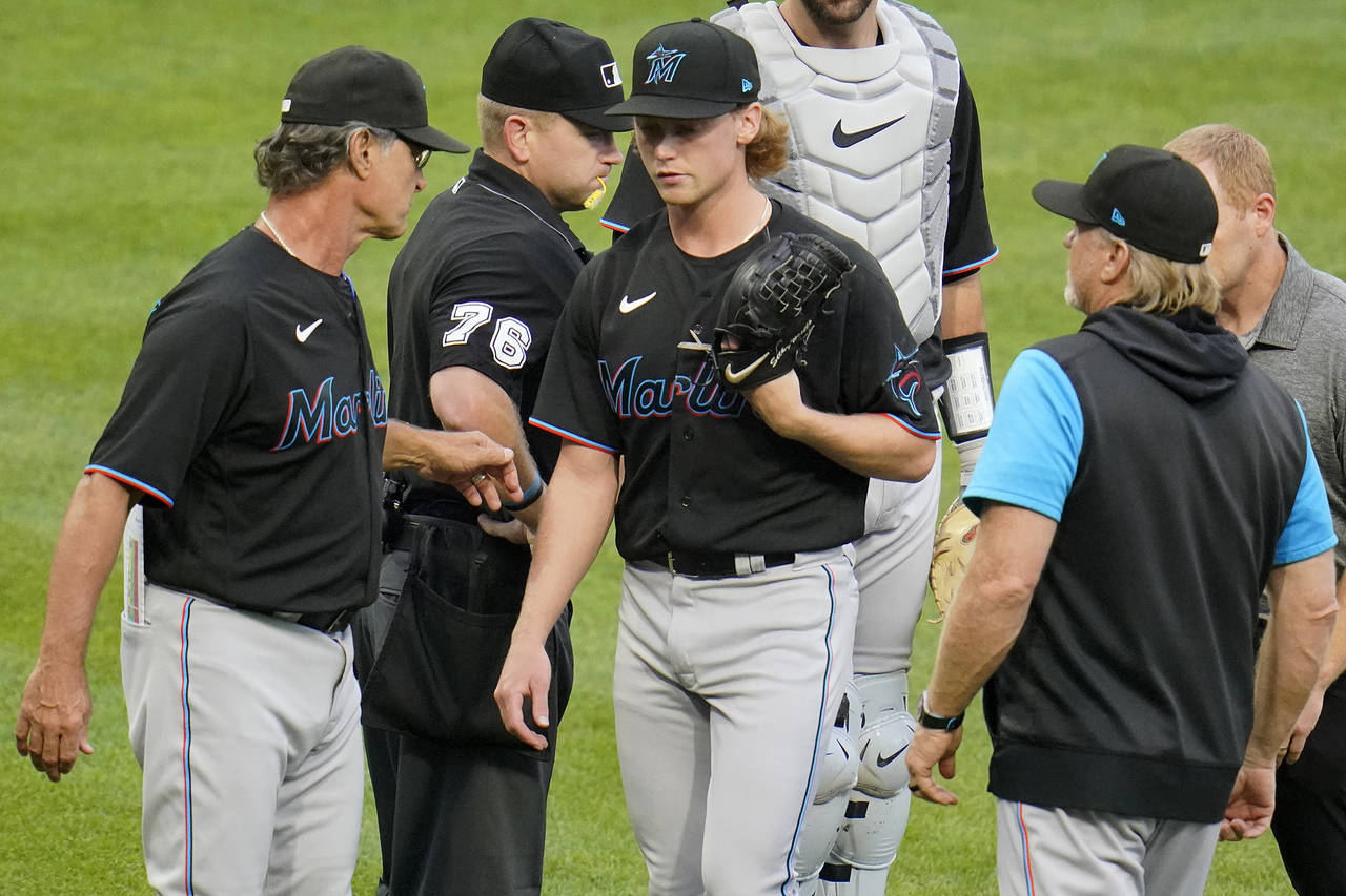 Miami Marlins starting pitcher Max Meyer, center, walks off the mound past manager Don Mattingly, l...