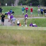 
              Fans and tournament staff make their way off the course after play was suspended due to inclement weather during the third round of the 3M Open golf tournament at the Tournament Players Club in Blaine, Minn., Saturday, July 23, 2022. (AP Photo/Abbie Parr)
            