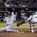
              Colorado Rockies' Jose Iglesias (11) scores as Arizona Diamondbacks catcher Carson Kelly attempts to make a tag during the ninth inning of a baseball game Thursday, July 7, 2022, in Phoenix. The Rockies won 4-3. (AP Photo/Ross D. Franklin)
            
