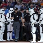 
              Umpires Andy Fletcher, left, and Junior Valentine are flanked by "Star Wars" stormtroopers as they walk on the field during Star Wars night, prior to a baseball game between the Arizona Diamondbacks and the Washington Nationals on Saturday, July 23, 2022, in Phoenix. (AP Photo/Ross D. Franklin)
            