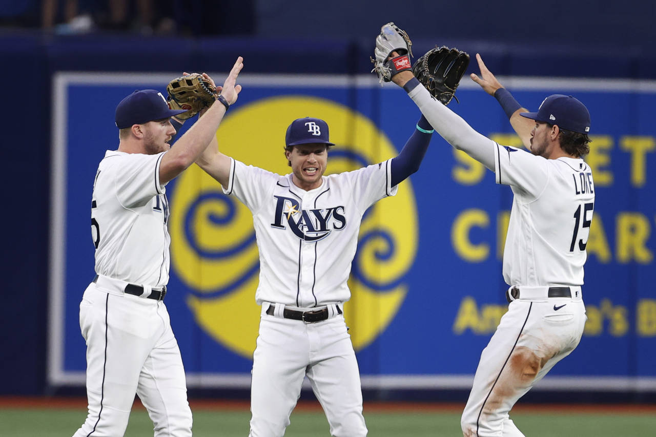 Tampa Bay Rays' Brett Phillips, center, celebrates with Luke Raley, left, and Josh Lowe after the R...