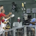 
              Fans reach for the ball as a television cameraman ducks, on a two-run home run by Chicago Cubs' Nelson Velazquez against the Philadelphia Phillies during the eighth inning of a baseball game, Friday, July 22, 2022, in Philadelphia. (AP Photo/Laurence Kesterson)
            